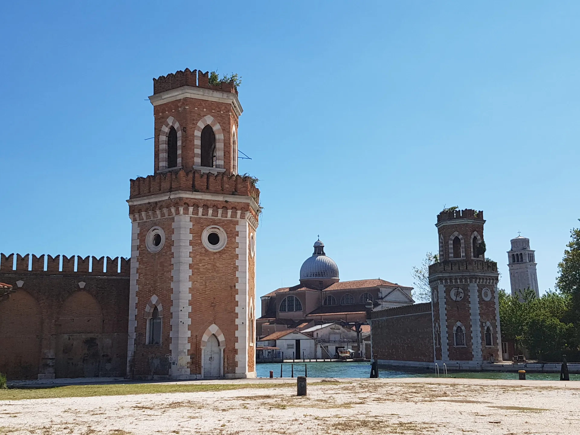 Brick towers of the Arsenale water gate and crenellated walls seen from inside the Arsenale, Venice