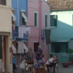 Abitanti di Burano chiacchierano davanti alle case color pastello, laguna di Venezia