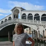 Daniela Zarpellon, guida turistica abilitata a Venezia, sorridente sul Canal Grande al Ponte di Rialto