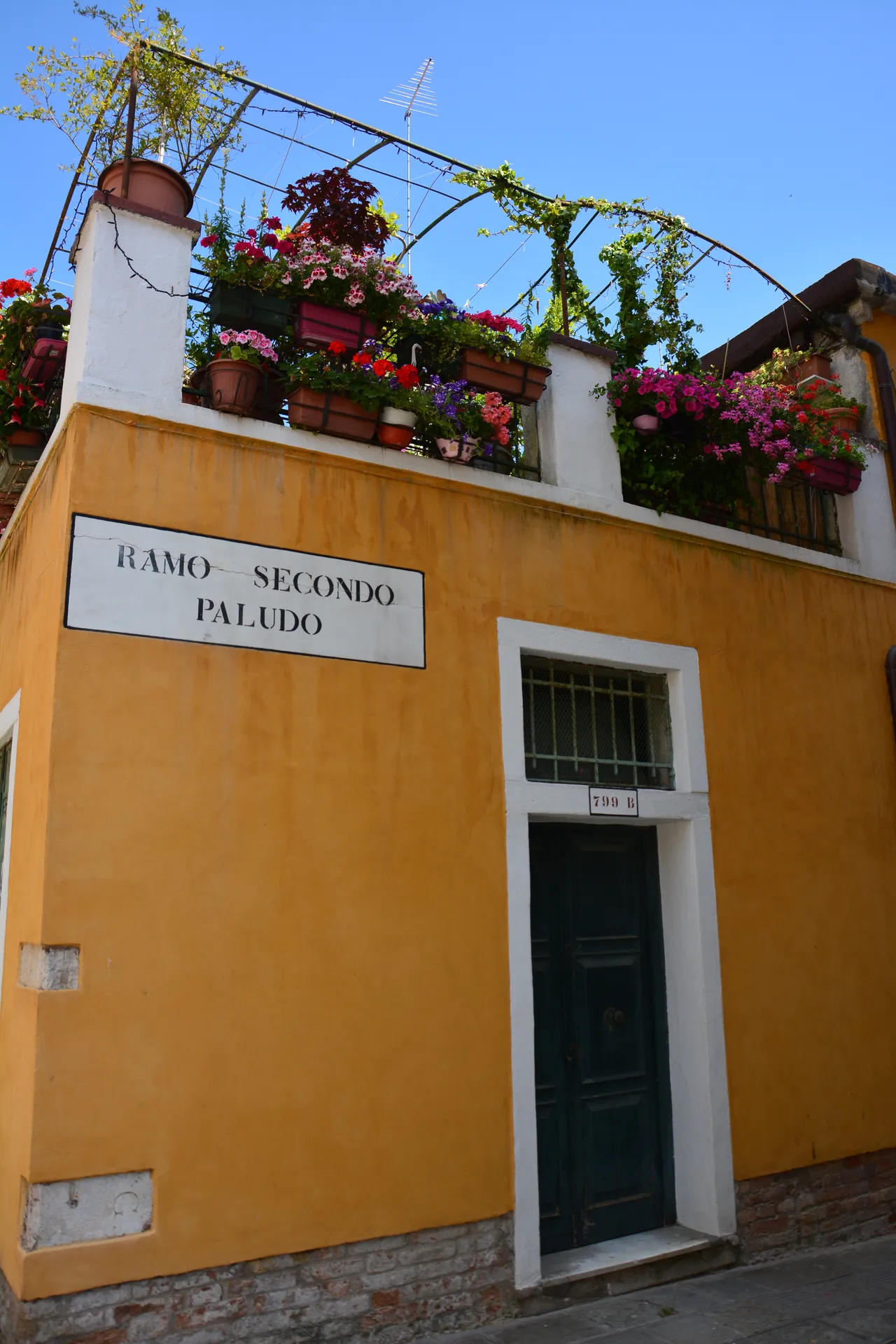 Casa color ocra con il nizioleto Ramo Secondo Paludo e una terrazza fiorita, Venezia
